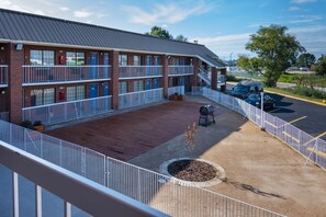 A two-story motel with a covered deck, outdoor seating, and a parking area. - Motel 6 Montgomery, AL - Coliseum (Montgomery)