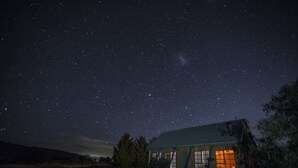 A rustic cabin with a starry night sky. - Charles Reuben Estate (Tea Tree)