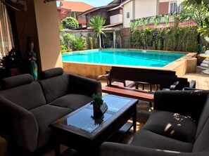 Ein Poolbereich mit einer Couch, einem kleinen Tisch und einer Bank.