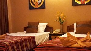 A hotel room with two beds, each with a brown headboard, a nightstand with a telephone, and a vase with yellow flowers. - Teeraya Boutique Guesthouse - Hostel (Chiang Mai)
