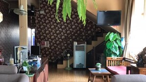 A cozy hotel lobby with a staircase, a bar area, and seating. - Teeraya Boutique Guesthouse - Hostel (Chiang Mai)