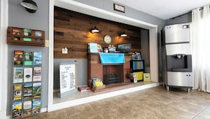 A reception area with a wooden wall, a fireplace, a water dispenser, and a sign indicating the sale of a board game.
