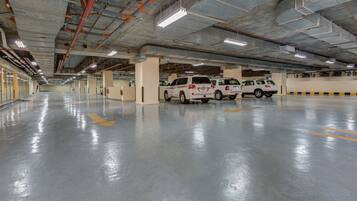A spacious parking garage with multiple white SUVs parked.