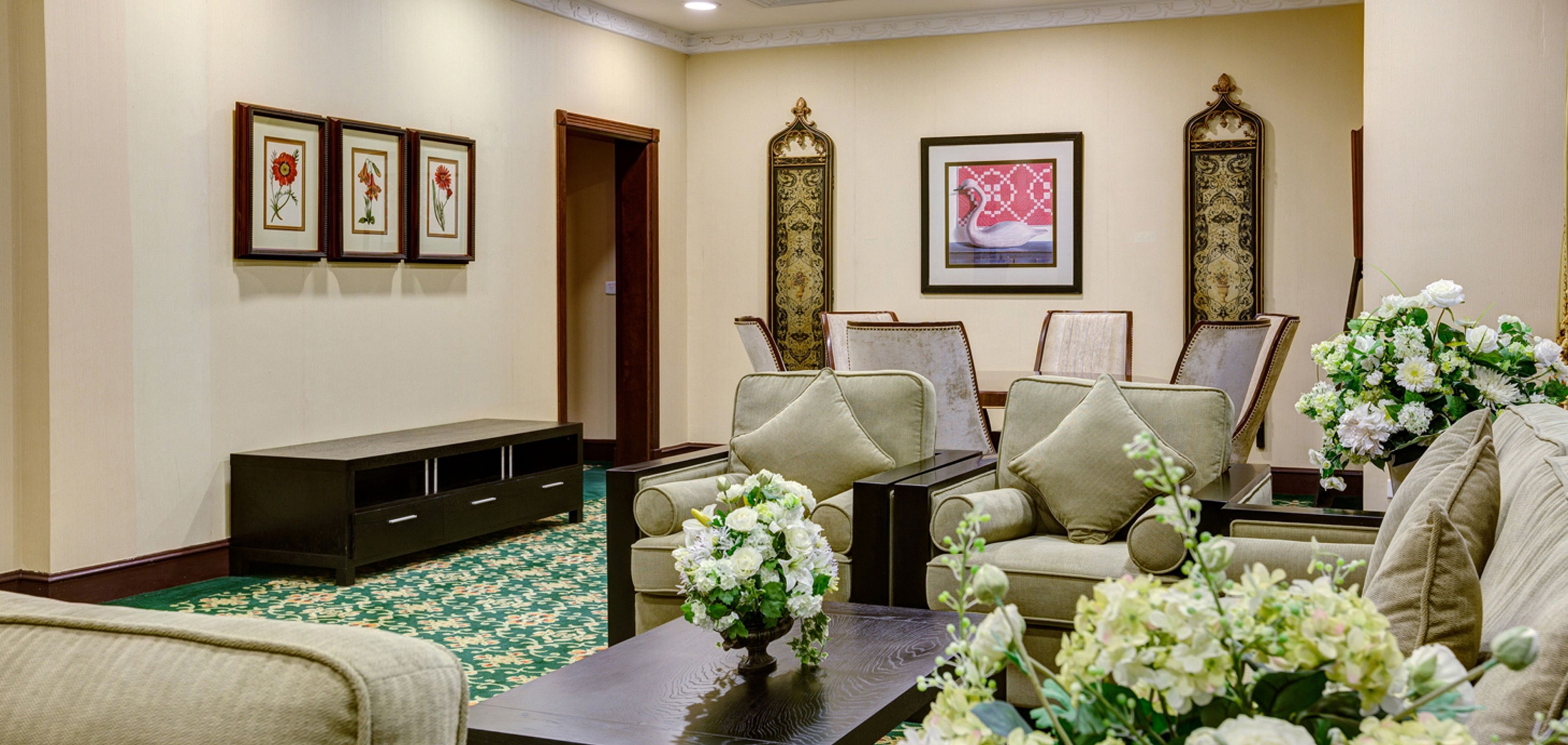 Una sala de estar elegantemente decorada con un conjunto de sofás, una mesa de centro y un jarrón decorativo con flores.