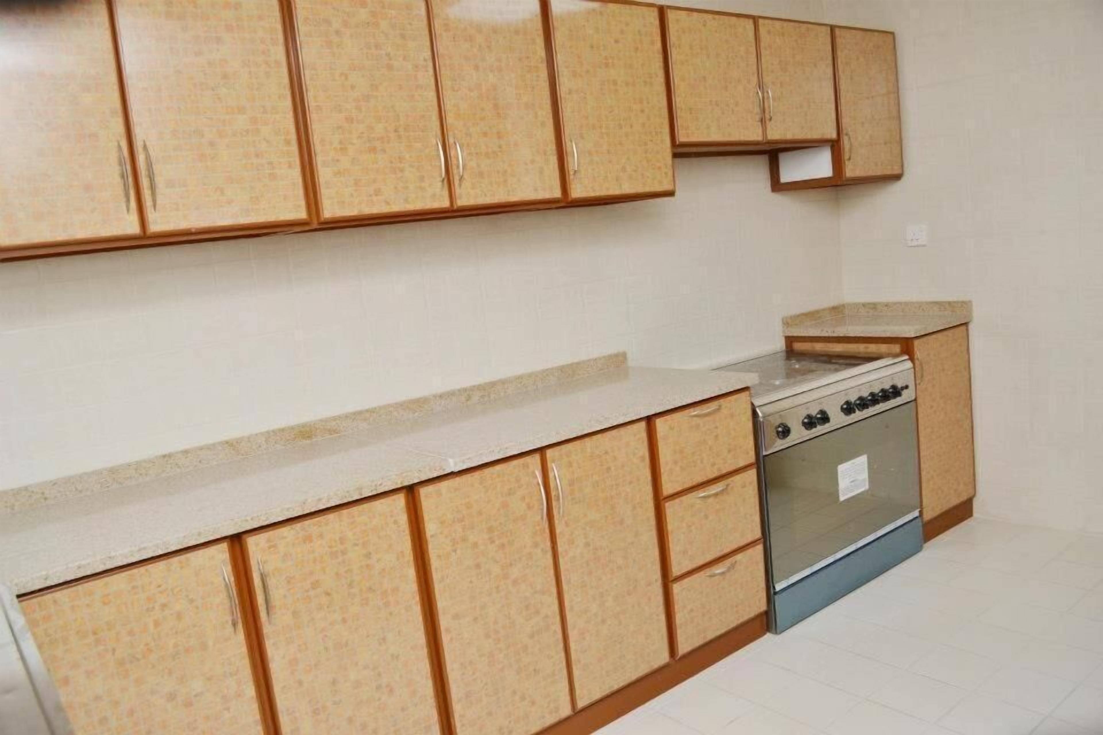 Cozinha com armários de madeira, bancada e forno embutido.