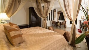 Een slaapkamer met een groot bed, een bureau en een stoel.