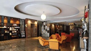 Un vestíbulo moderno con una zona de estar central, un bar y una exhibición de productos.