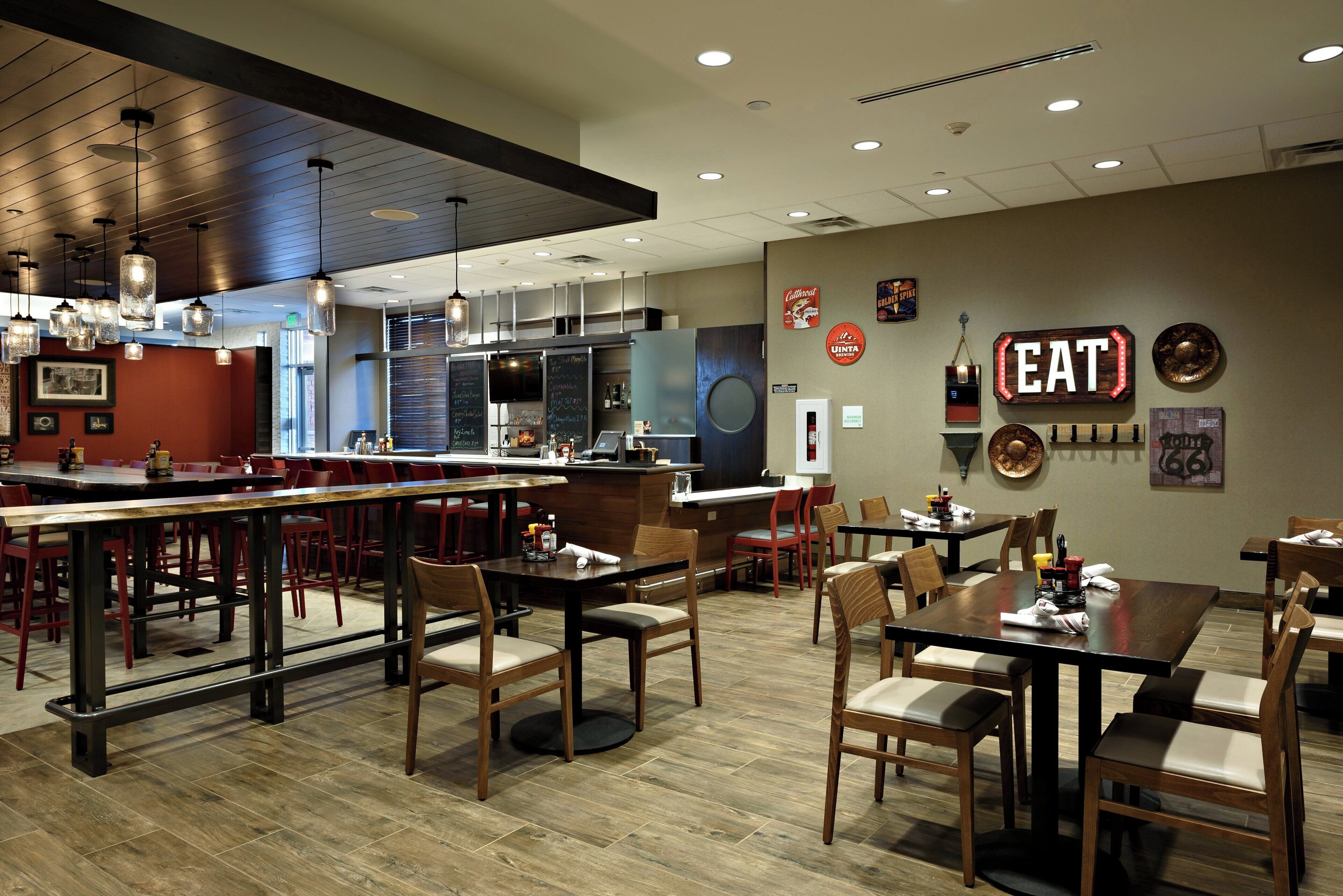 A restaurant interior with a bar area, dining tables, and chairs.