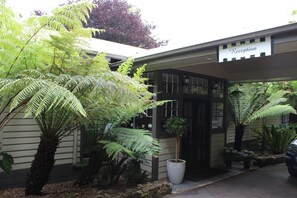 A reception area with a sign, a potted plant, and a car parked outside. - Belle Le Vie (Sassafras)
