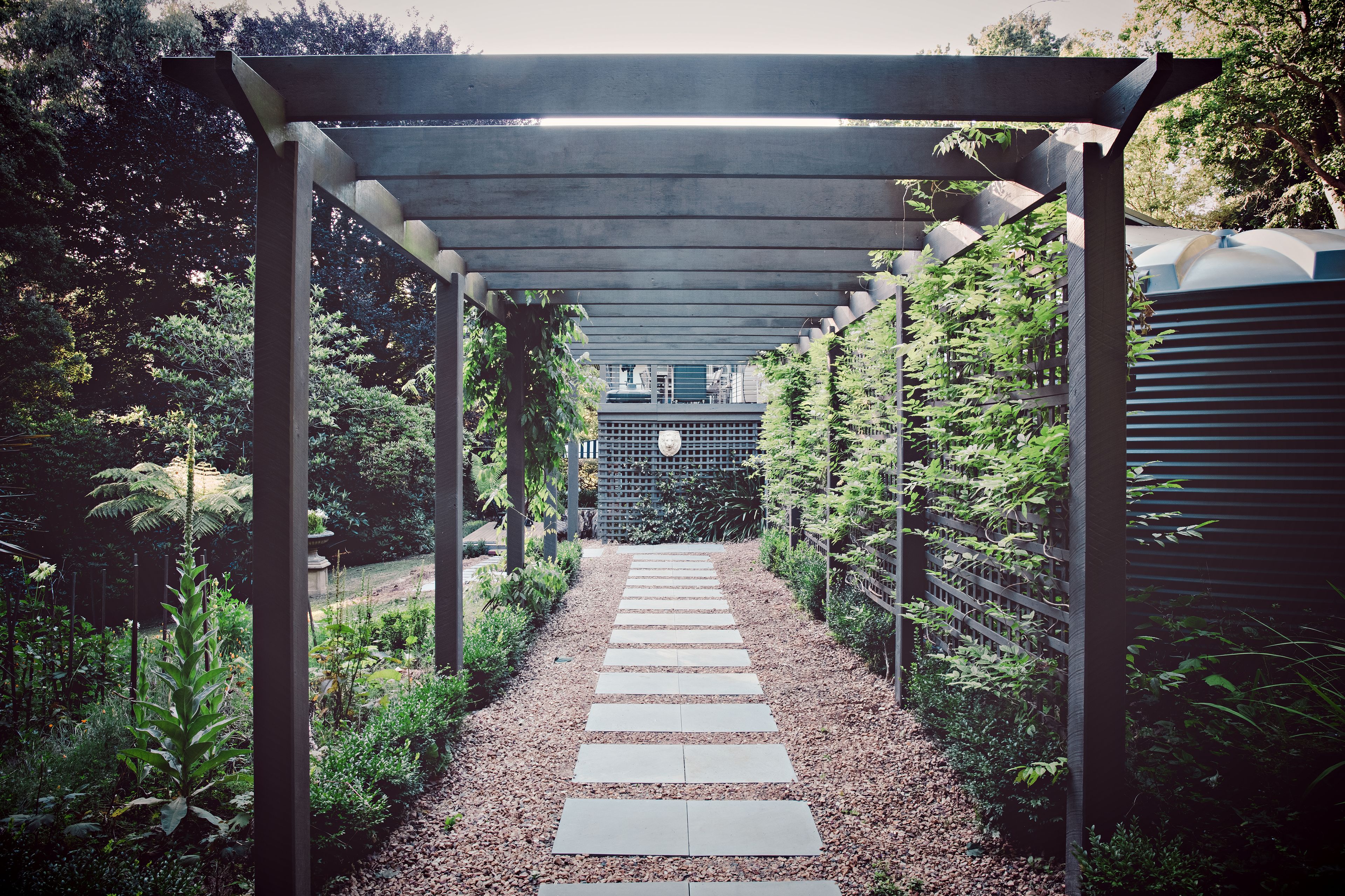 A covered pathway with a gravel surface leading to a building.
