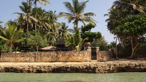 A coastal property with a stone wall, a small gate, and a clear view of the sea. - WB Villa (Unawatuna)