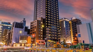 Un grand hôtel, reconnaissable à son enseigne imposante, entouré d’autres immeubles et de matériel de construction.