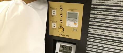 A hotel room control panel with a digital clock displaying 6:51.