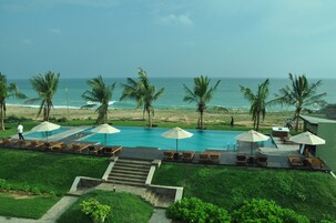 Una piscina al aire libre, camas de piscina gratis, sombrillas