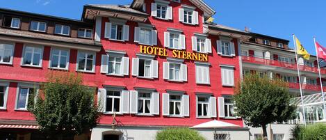 Un edificio rojo con la fachada que dice "HOTEL STERNEN".