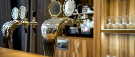 A bar with two taps and a shelf of glasses.