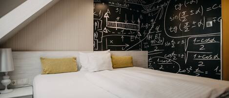 Un dormitorio con cama, mesita de noche y una pared con ecuaciones matemáticas.