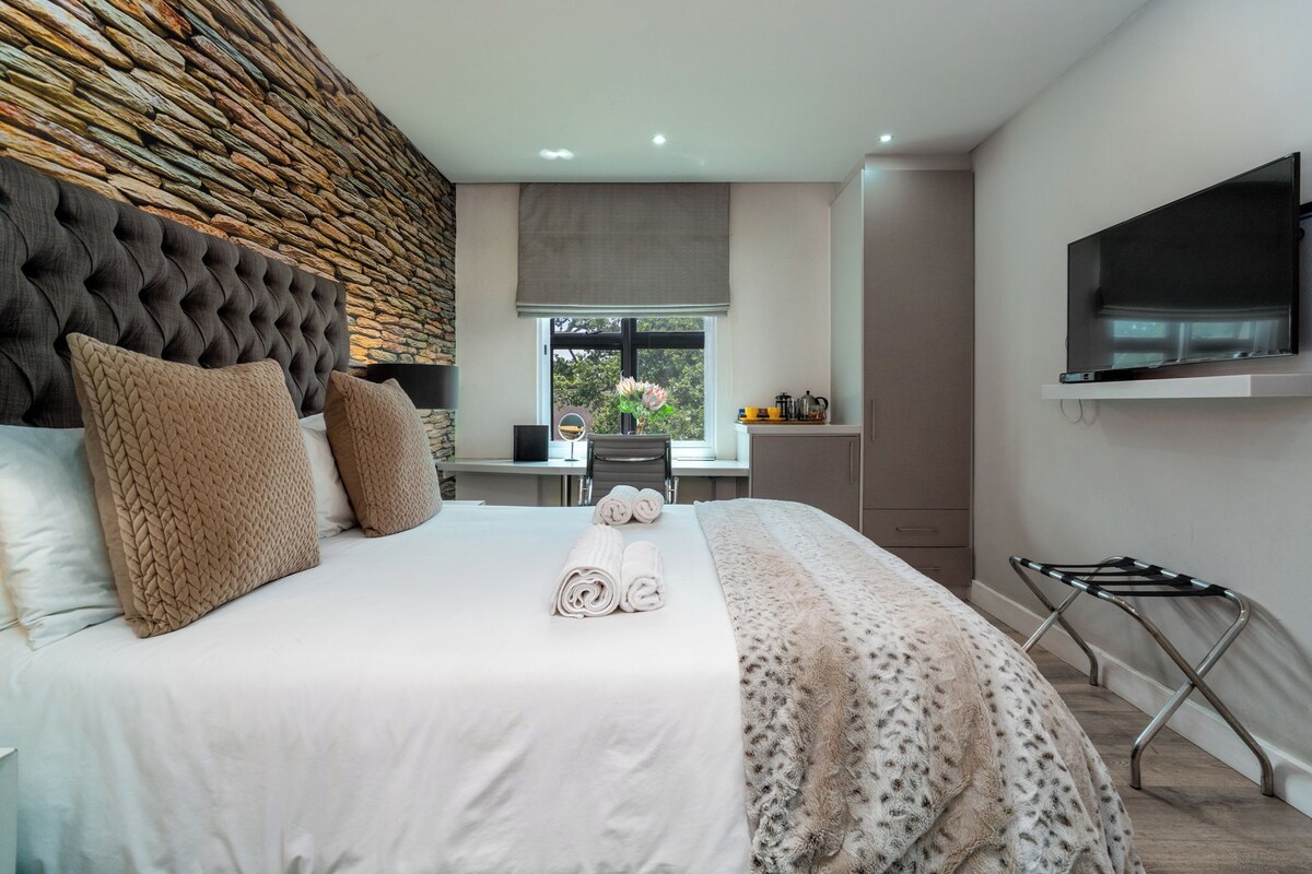 Une chambre d’hôtel moderne avec un grand lit, un bureau et une télévision.