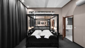 Una habitación de hotel moderna con cama de dos plazas, un espejo grande y vistas a la ciudad a través de la ventana.