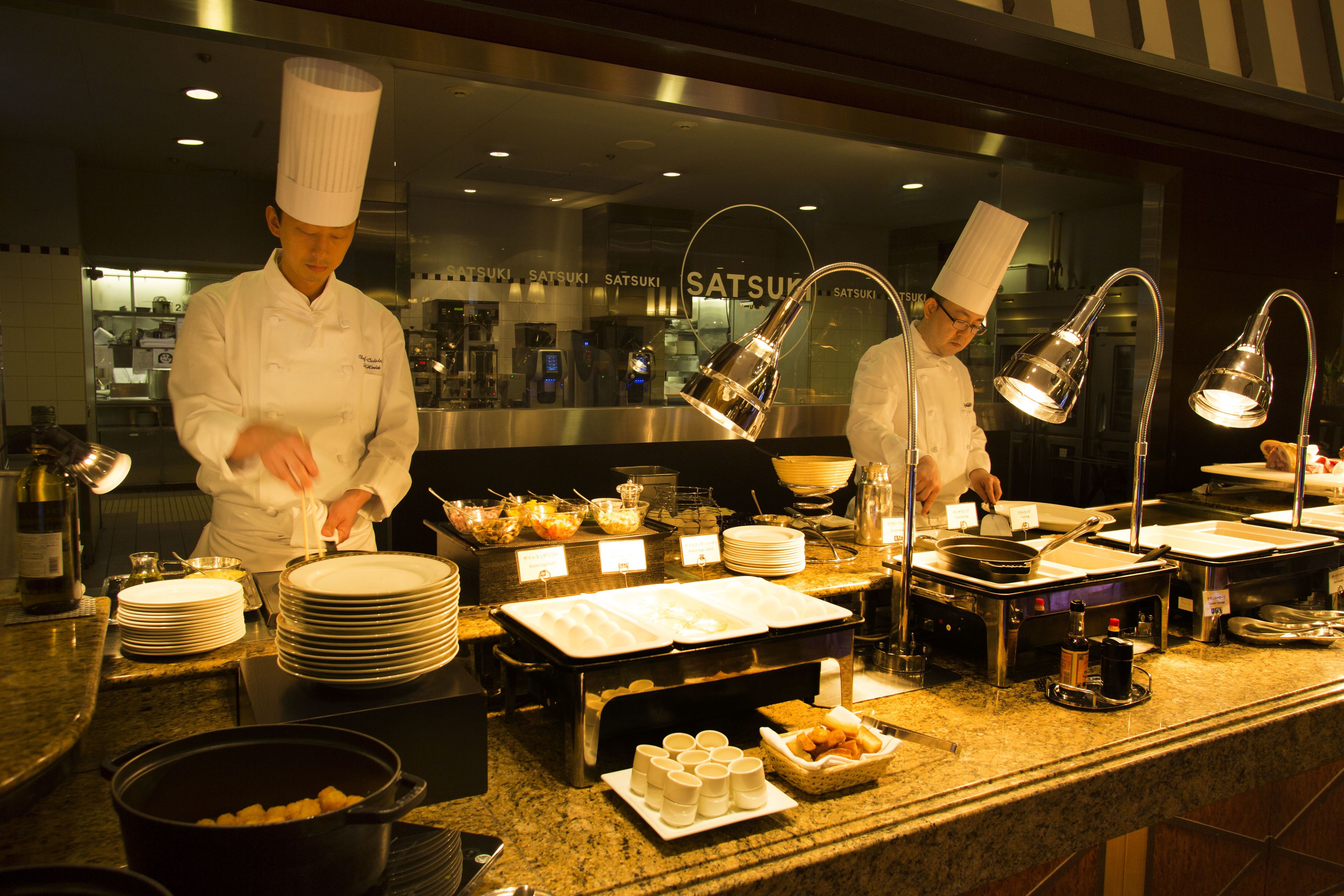 Un buffet avec plusieurs points de service, proposant une variété de plats et d’ustensiles.