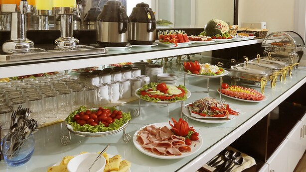 Un buffet proposant une variété de plats et d’ustensiles.