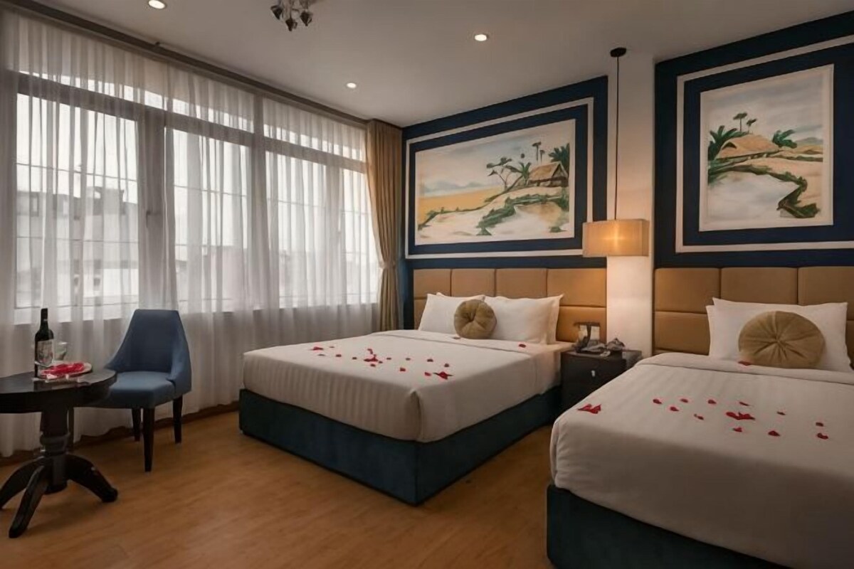 Een hotelkamer met twee bedden, een bureau en een stoel.