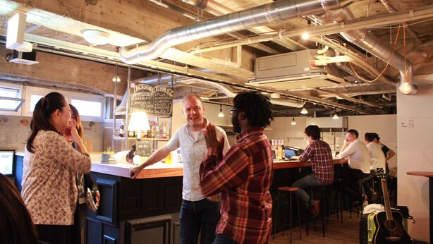 A bar area with exposed ductwork and wooden beams. - Hostel and Dining Tanga Table (Kitakyushu)
