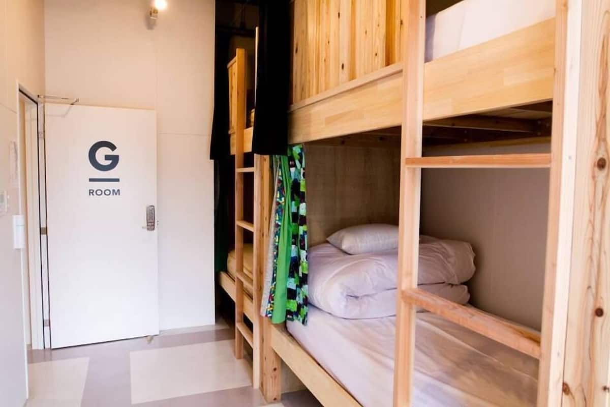 Ein Schlafzimmer mit Etagenbetten und einer Tür mit der Aufschrift 'G ROOM'.