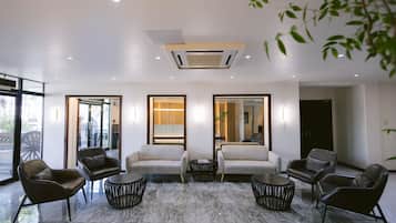 A modern interior with a sofa set, armchairs, and a coffee table.