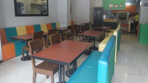 A restaurant with booths and tables, a counter, and a mirror on the wall. - Getz Hotel (Manila)
