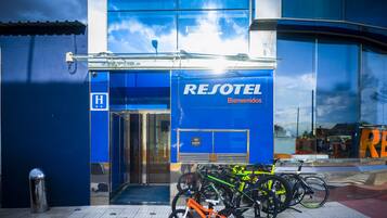 Entrada de un hotel azul con un letrero que dice "RESOTEL Bienvenidos".