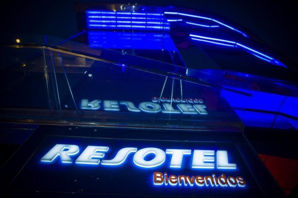 Placa com 'RESOTEL' e 'Bienvenidos' indicando a entrada de um hotel.