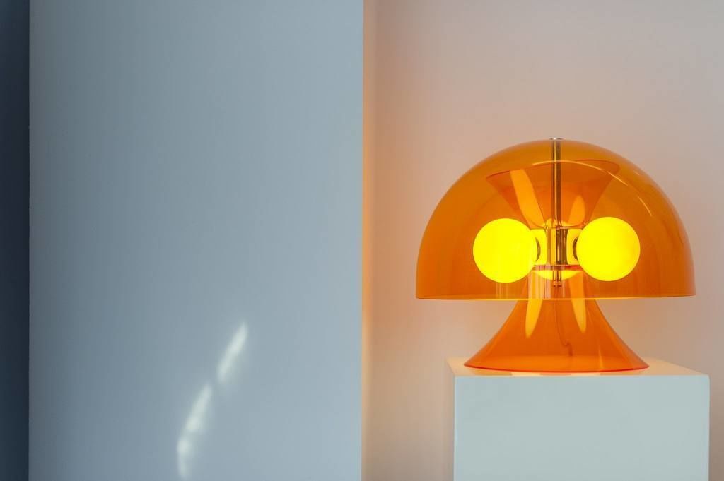 Una lámpara moderna con una parte superior esférica y dos luces amarillas.