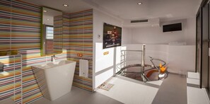 A modern bathroom with a striped wall design, a large mirror, a bathtub, and a shower area. - Resotel (Villares de la Reina)