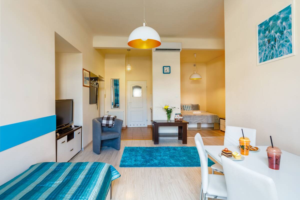 Departamento Confort, 2 habitaciones, vista a la ciudad | Sala de estar | Televisión de pantalla plana de 42 pulgadas con canales vía satélite 