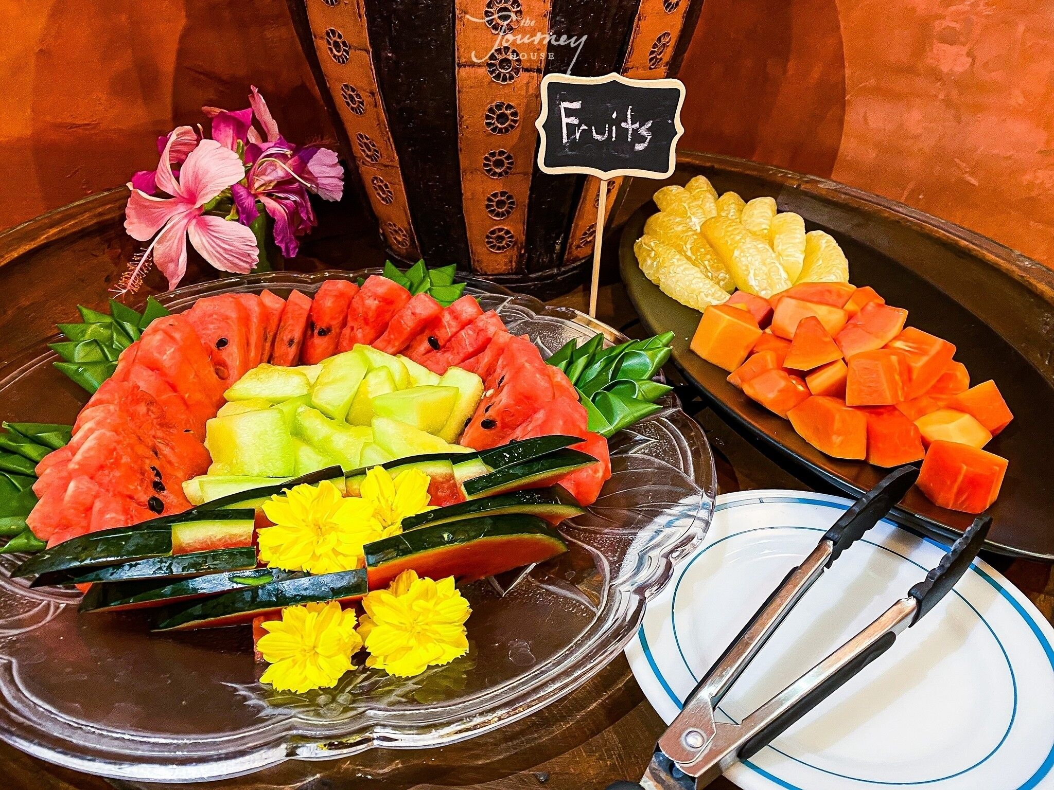 Una exhibición de frutas con diversos tipos y un letrero que dice 'Frutas'.