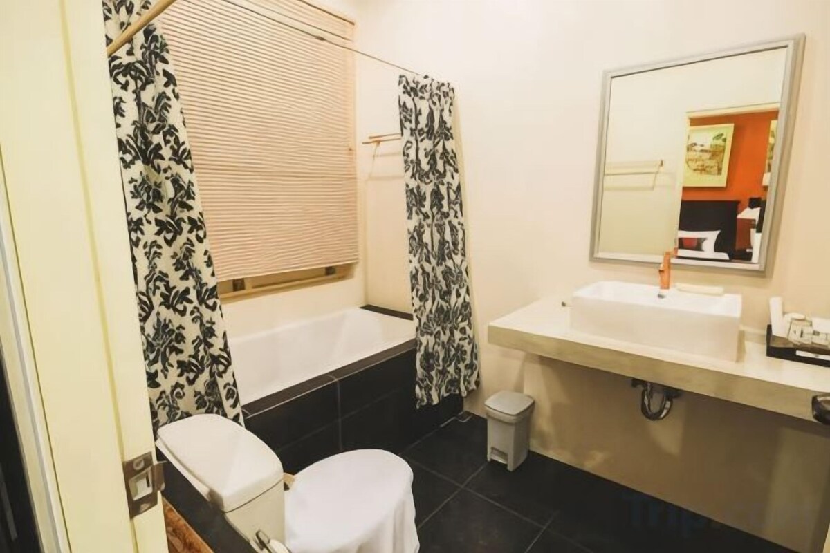 Un baño con bañera, inodoro, lavabo y espejo.