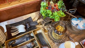 Een buffetopstelling met diverse gerechten en bestek.