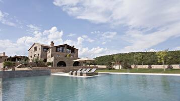 Una piscina al aire libre, tumbonas
