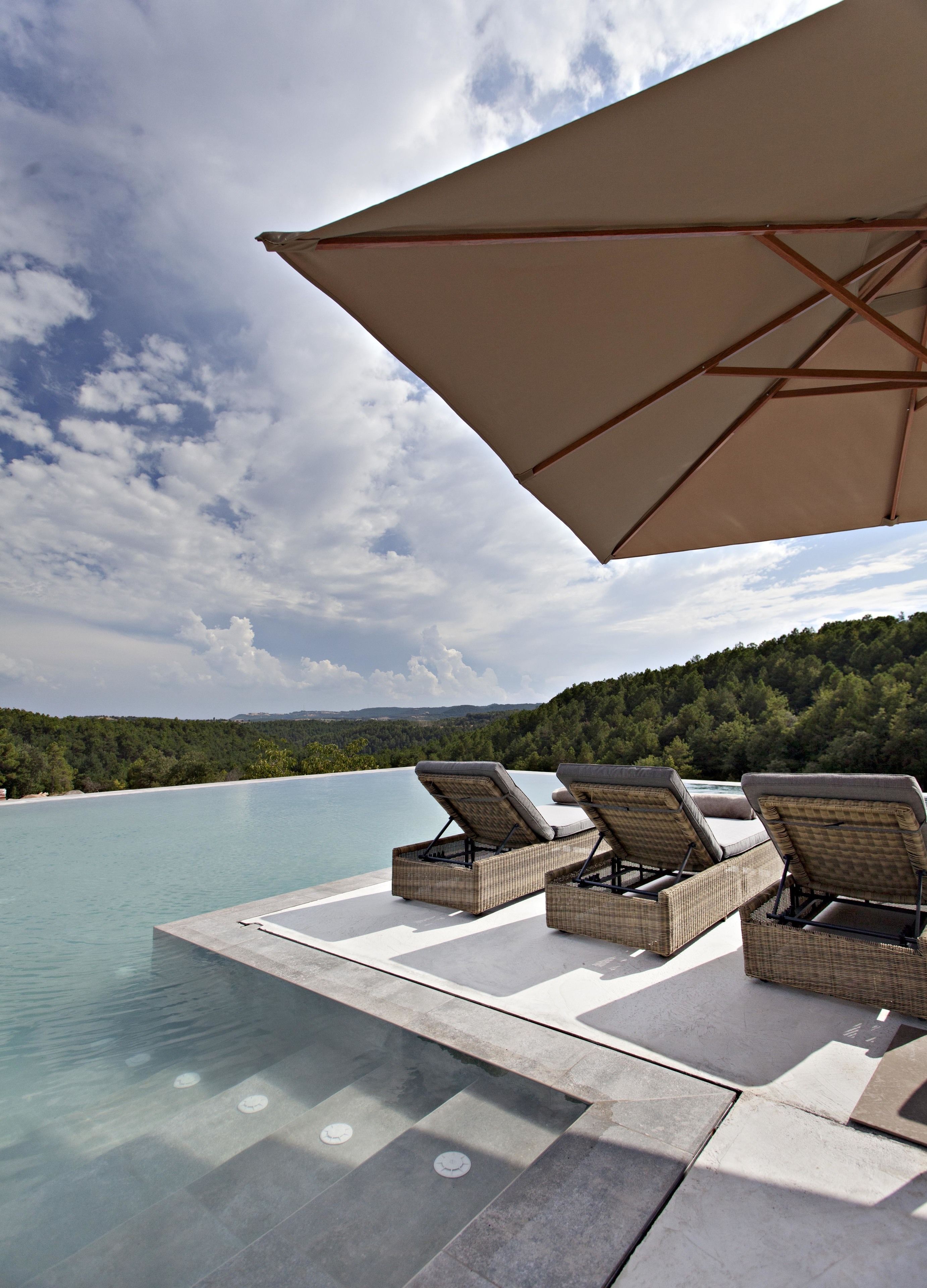 Una piscina al aire libre, tumbonas