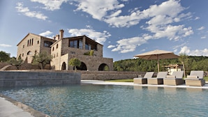 A stone building with a pool and lounge chairs. - Hotel La Vella Farga (Lladurs)