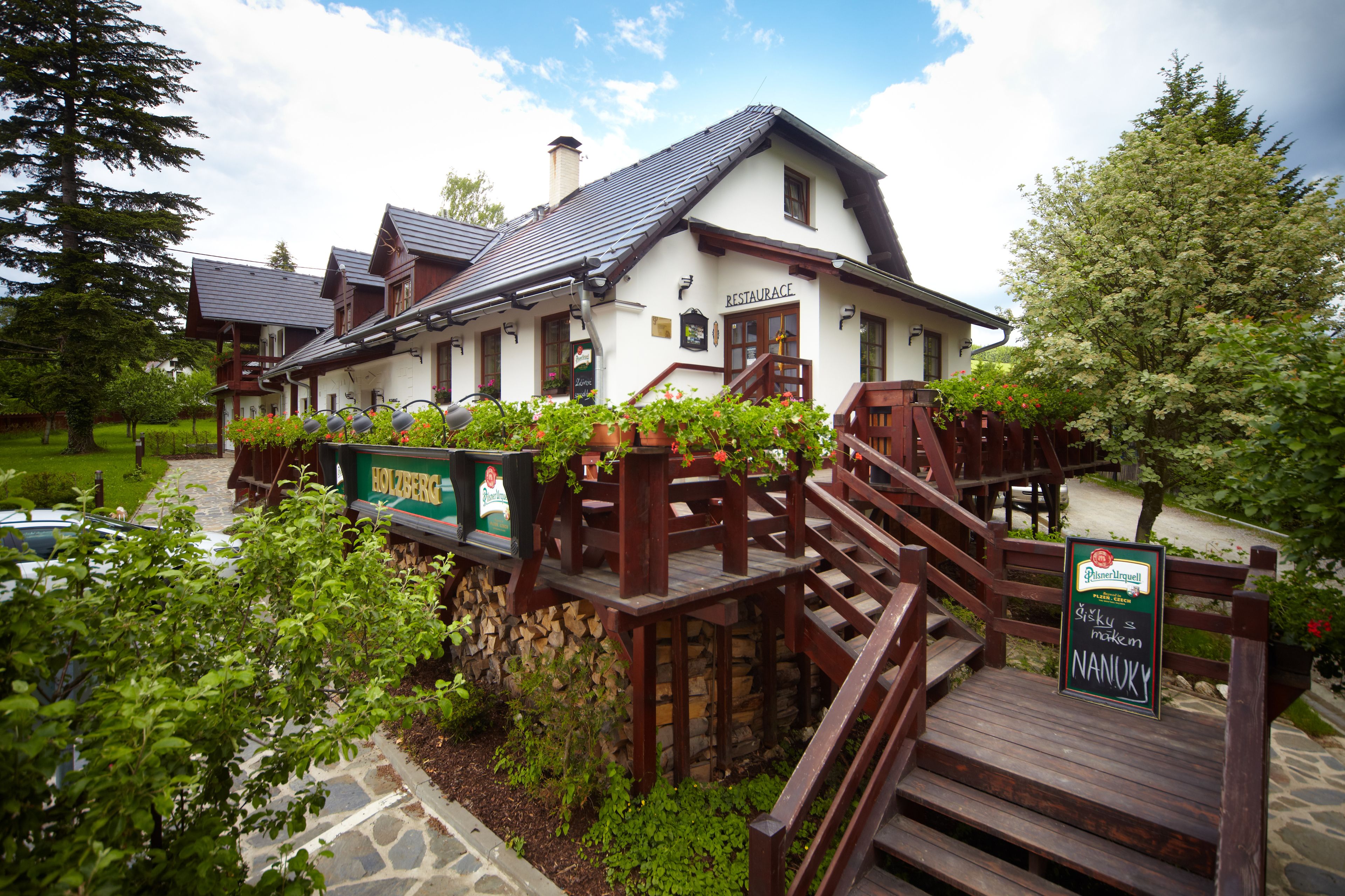 A traditional building with a sign reading "RESTAURANCE" and a wooden staircase leading to a deck.