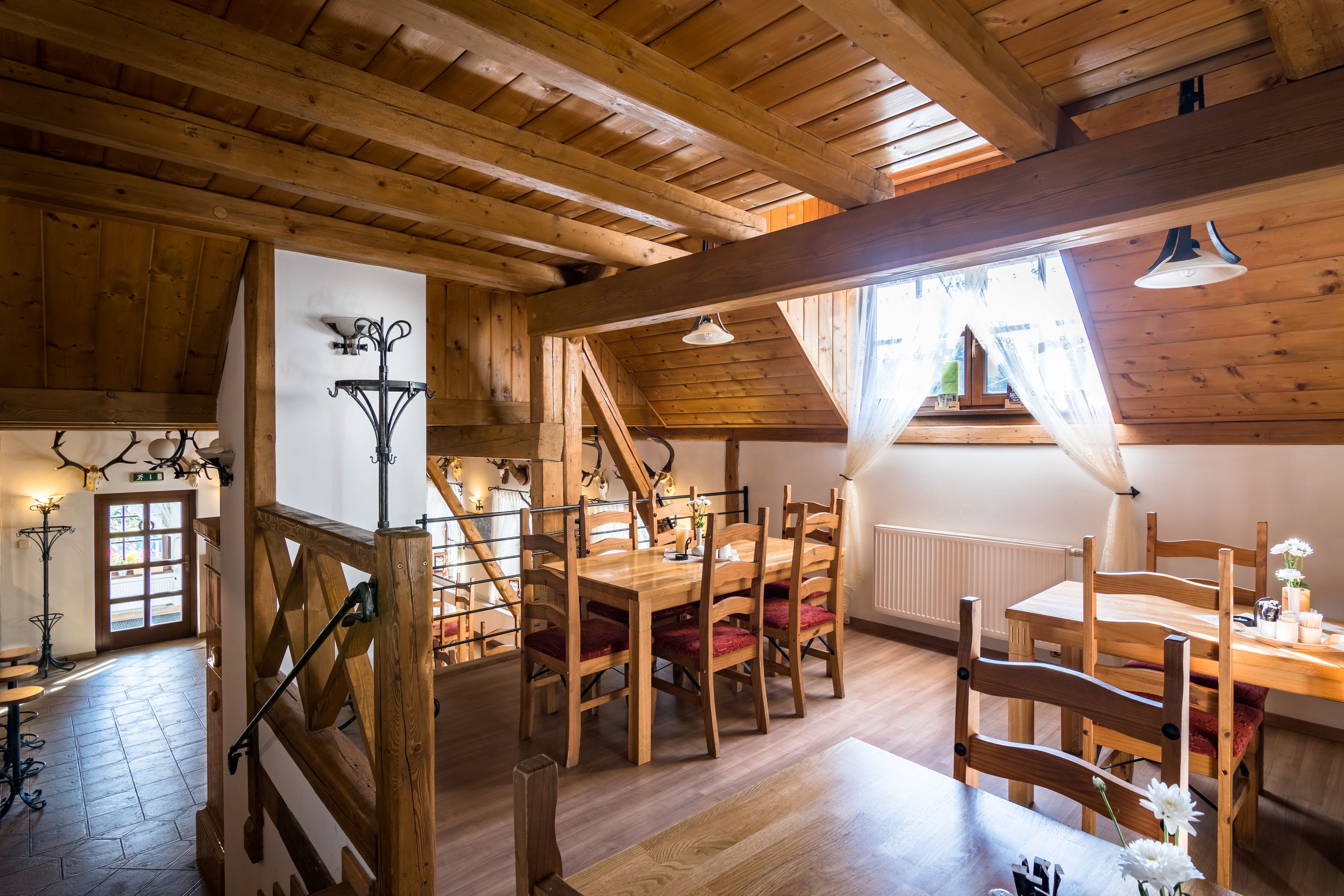 Un interior de madera con zona de comedor, escalera y vistas al exterior.