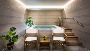 Un espace bien-être comprenant un jacuzzi, des marches en bois et deux chaises.