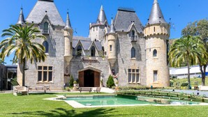 Un grand bâtiment en pierre, doté de nombreuses tours et d’une entrée centrale.