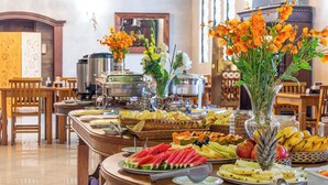 Un buffet garni de divers fruits et un grand vase rempli de fleurs.