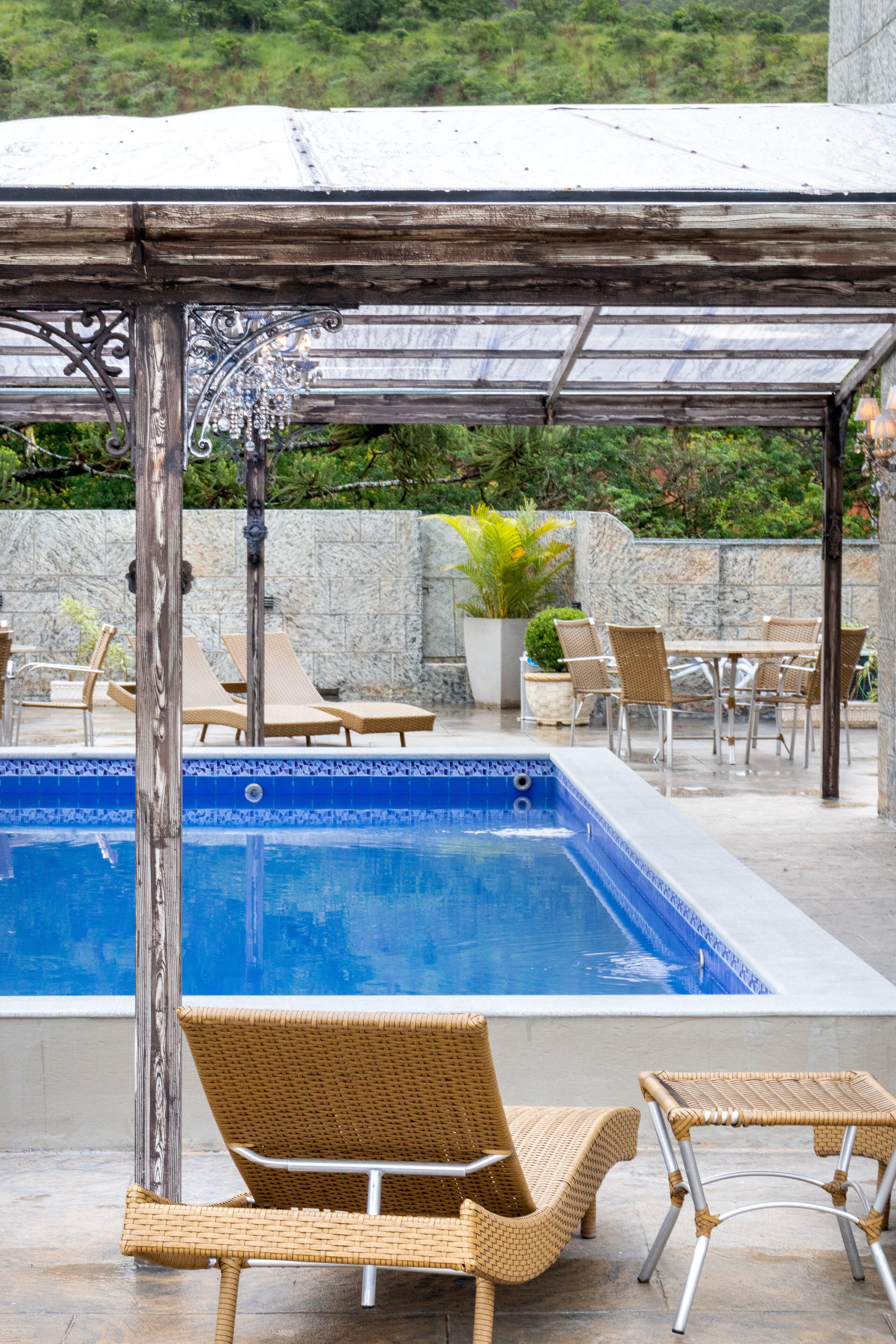 Una piscina al aire libre, sillones reclinables de piscina