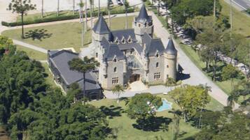 Surrounded by lush greenery, this castle-like building offers a serene retreat with a swimming pool and scenic views.