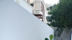 A small outdoor dining area with a table set for breakfast, including a pizza, coffee, and a plant. - Luna Piena B&B (Lecce)