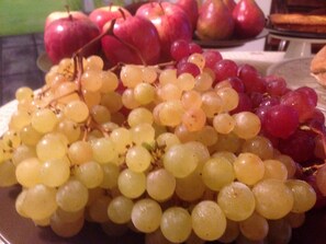 Un plato de uvas y manzanas.